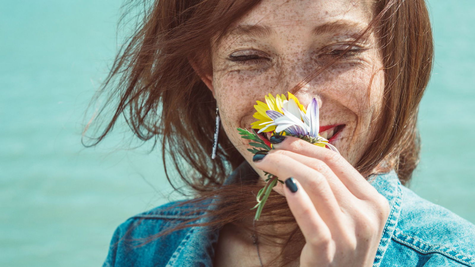 Frau riecht an Blumen Geruch